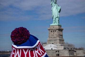Une tuque de New York et la Statue de la Liberté au loin.