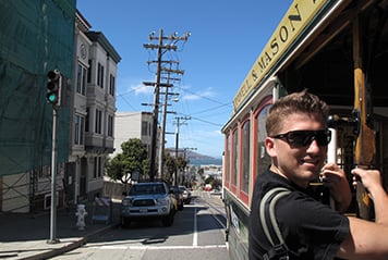 Étudiant sautant dans un tramway à San Francisco